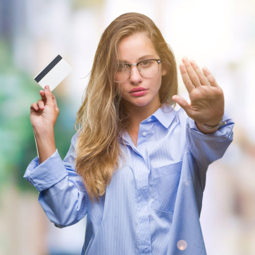 Young beautiful blonde woman holding credit card over isolated b